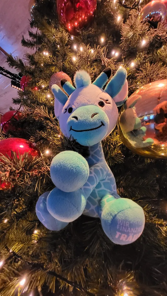 Raffi als Plüschgiraffe zwischen Weihnachtskugeln
